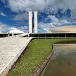 Vista externa do Congresso Nacional do Brasil, em Brasília, destacando sua arquitetura modernista sob um céu claro.