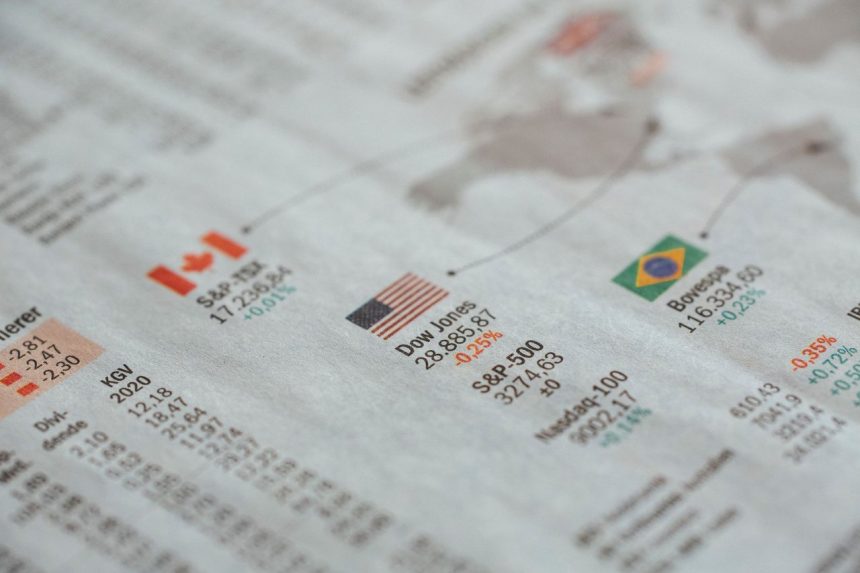 Close de um jornal com estatísticas de mercados financeiros globais e bandeiras de diferentes países.
