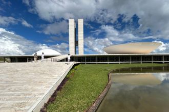 Vista externa do Congresso Nacional do Brasil, em Brasília, destacando sua arquitetura modernista sob um céu claro.