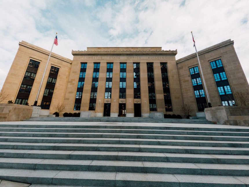 Exterior do Federal Reserve em Washington, visto de baixo, com bandeiras dos Estados Unidos e uma escadaria.