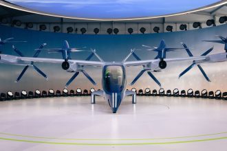 Protótipo de aeronave elétrica eVTOL com hélices exposto em ambiente interno.