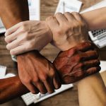 Grupo diverso de pessoas reunido em um ambiente de trabalho, simbolizando colaboração e participação institucional.