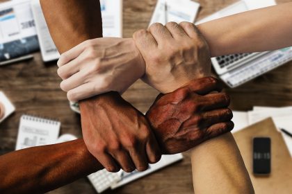 Grupo diverso de pessoas reunido em um ambiente de trabalho, simbolizando colaboração e participação institucional.