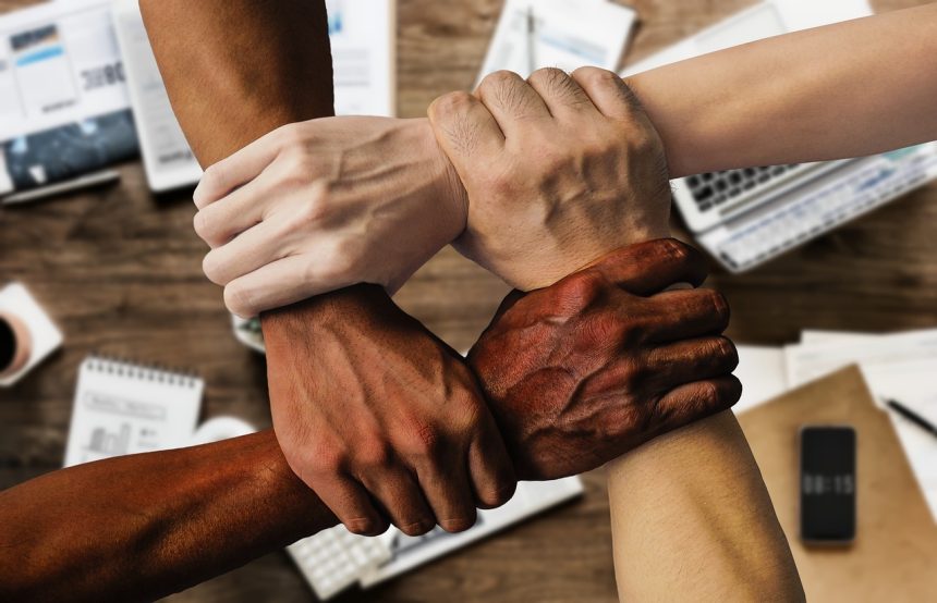 Grupo diverso de pessoas reunido em um ambiente de trabalho, simbolizando colaboração e participação institucional.